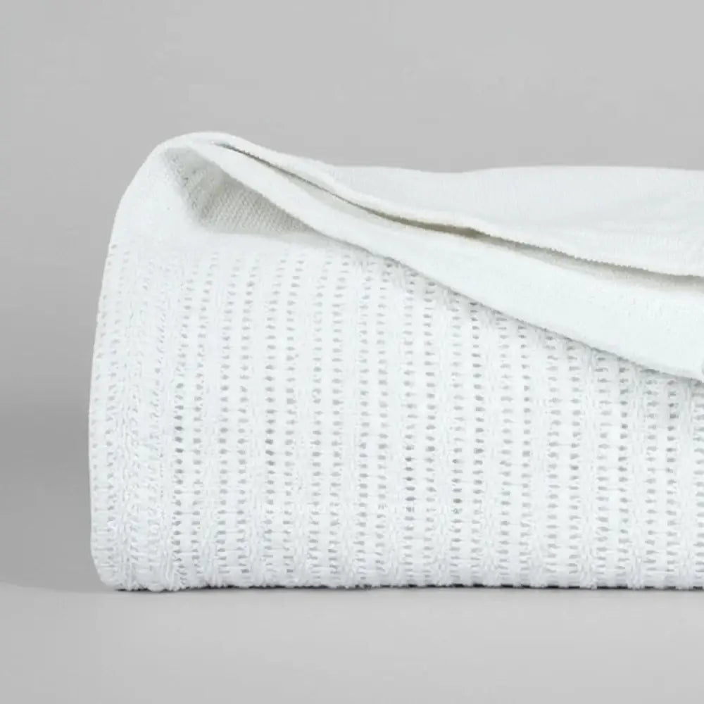 white cotton cellular blanket showing textured waffle weave fabric on neutral grey background—soft, breathable bedding by Linen & Co