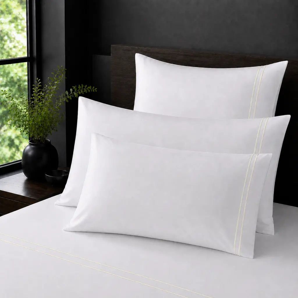 White Polycotton Percale 200TC pillow cases with cream two row satin stitch - on the bed - Linen and Co