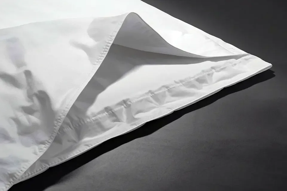 The corner of a white duvet cover opened at the bottom, showing the fabric envelope flap closure