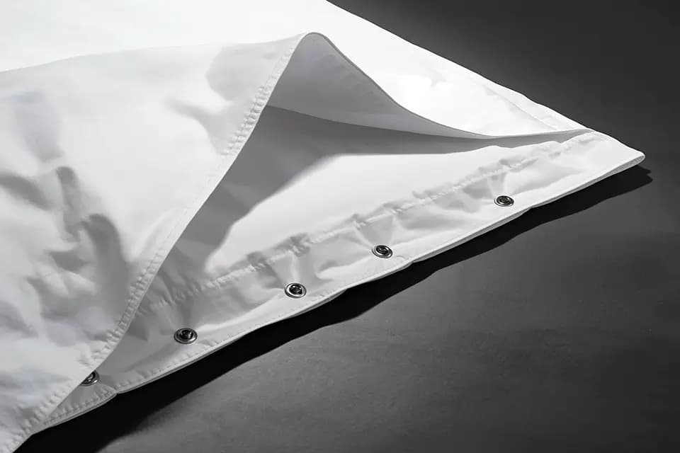 The corner of a white duvet cover opened at the bottom, showing the row of press studs along the closure