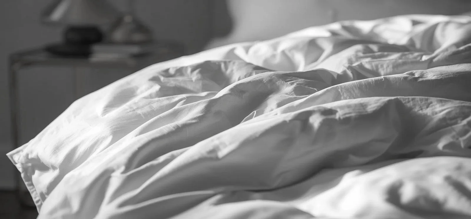 Soft folds of white polycotton percale bed linen, close up
