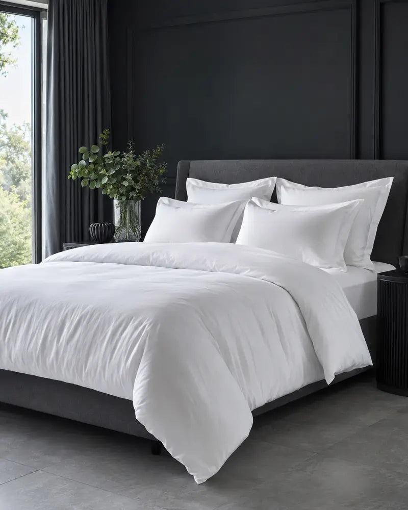 Luxury white bed linen on a charcoal bedroom background