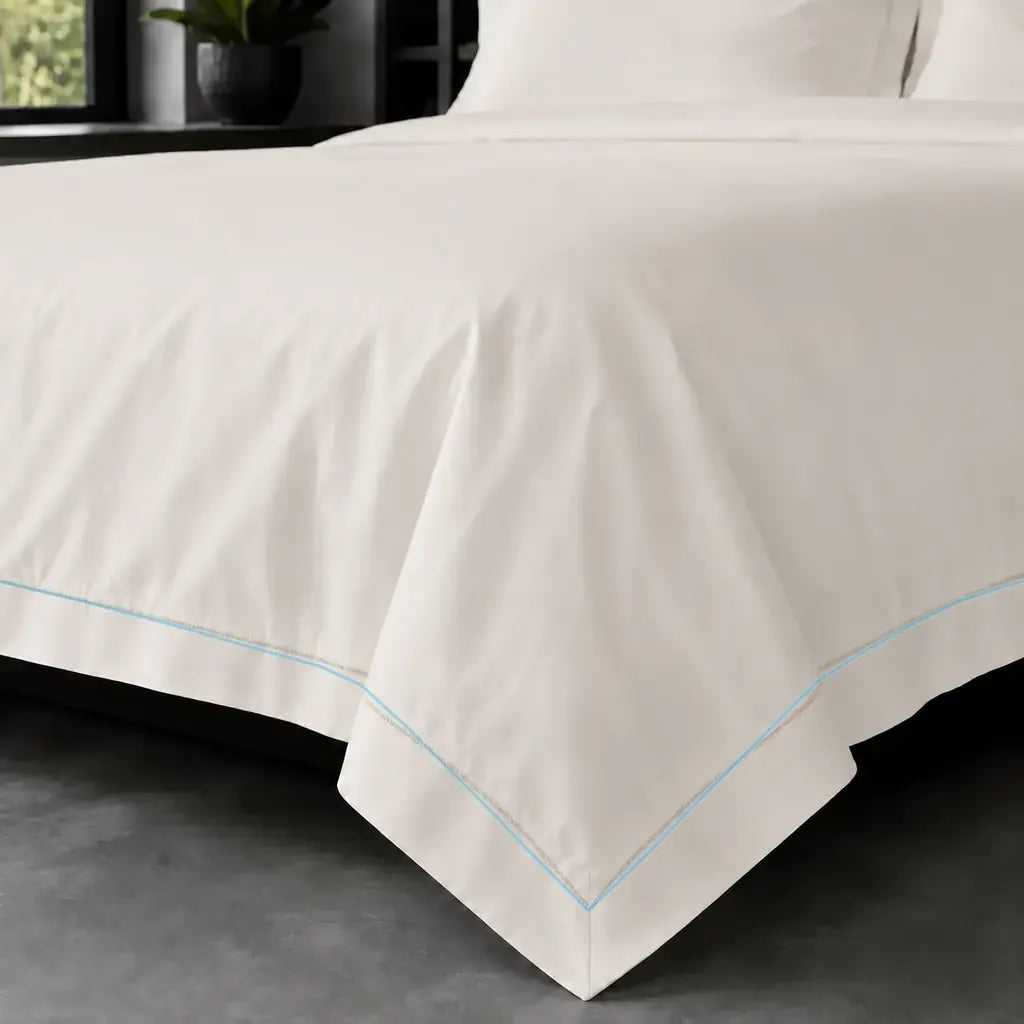 Cream polycotton percale 200TC Oxford duvet cover on bed with Duck Egg one-row satin stitch - Linen and Co