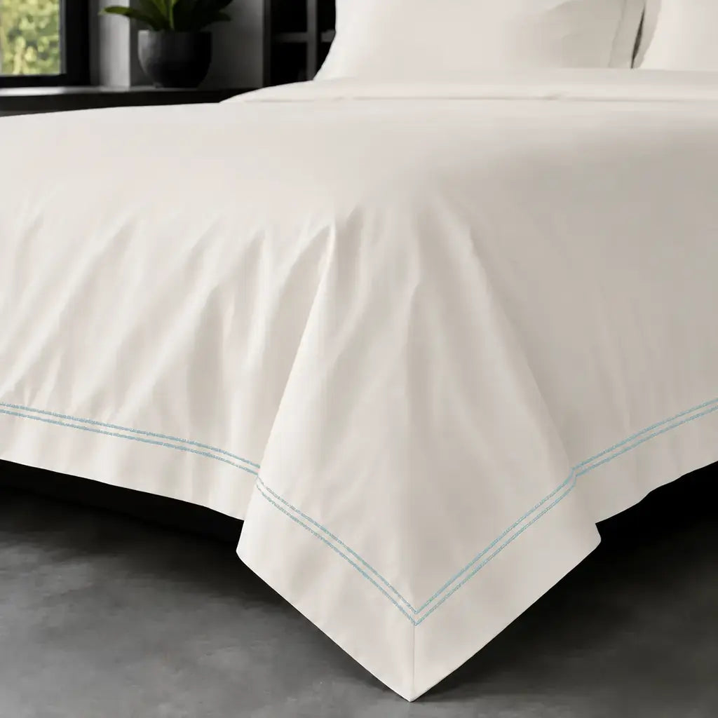 Cream polycotton percale 200TC Oxford duvet cover on bed with Duck Egg two-row satin stitch - Linen and Co