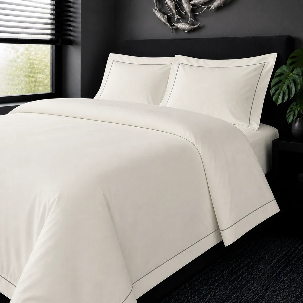 Cream cotton 200TC Oxford duvet cover set with grey one-row satin stitch – on-bed view | Linen & Co