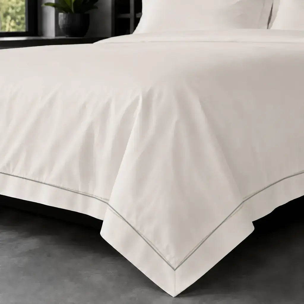 Cream polycotton percale 200TC Oxford duvet cover on bed with grey one-row satin stitch - Linen and Co