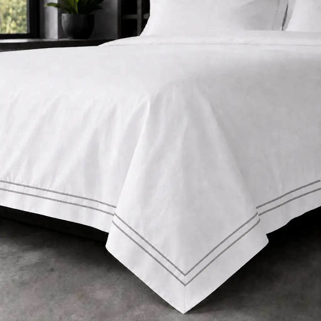 White polycotton percale Oxford duvet cover set with grey two-row satin stitch – on-bed view | Linen & Co