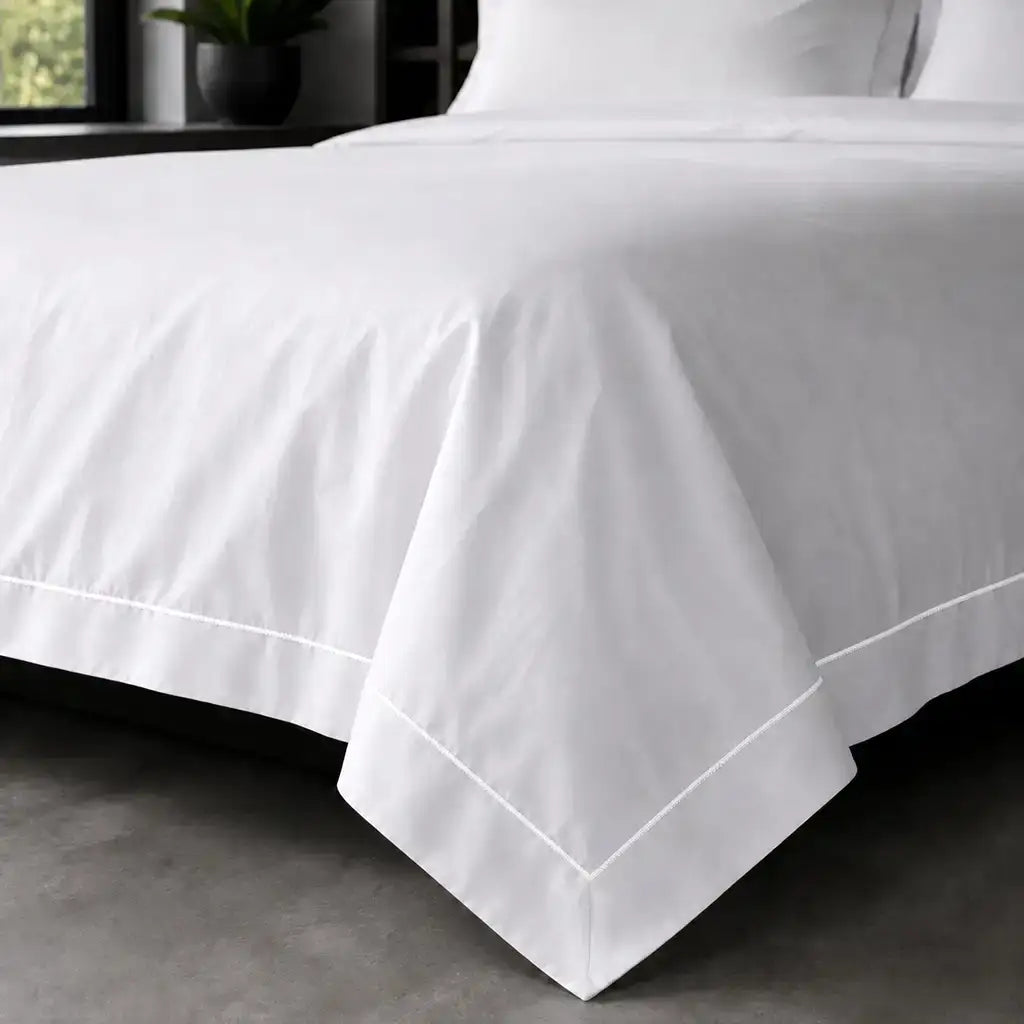 White polycotton percale Oxford duvet cover set with white one-row satin stitch – on-bed view | Linen & Co