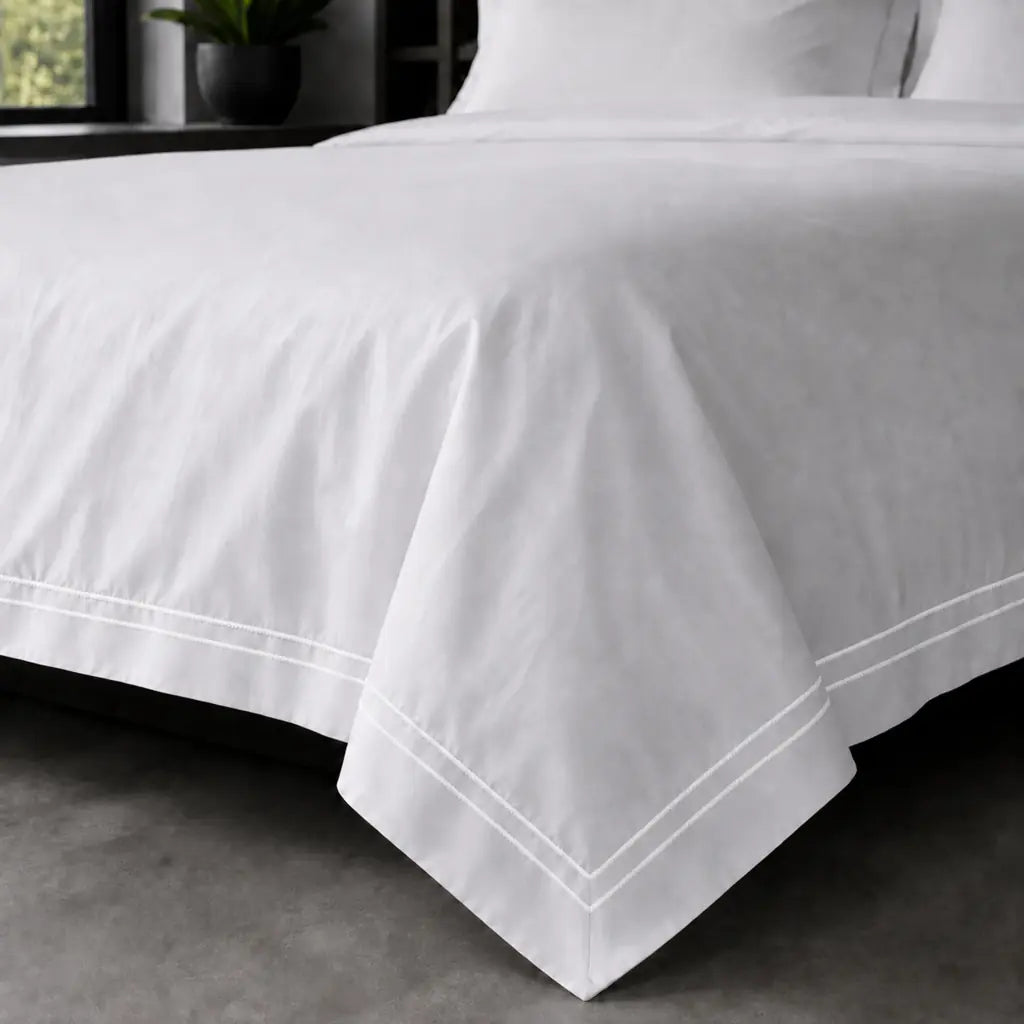 White polycotton percale Oxford duvet cover set with white two-row satin stitch – on-bed view | Linen & Co