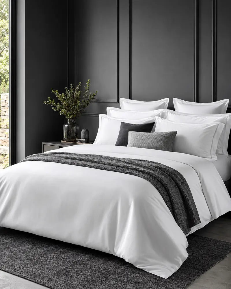 Complete layered white bed linen in a charcoal bedroom