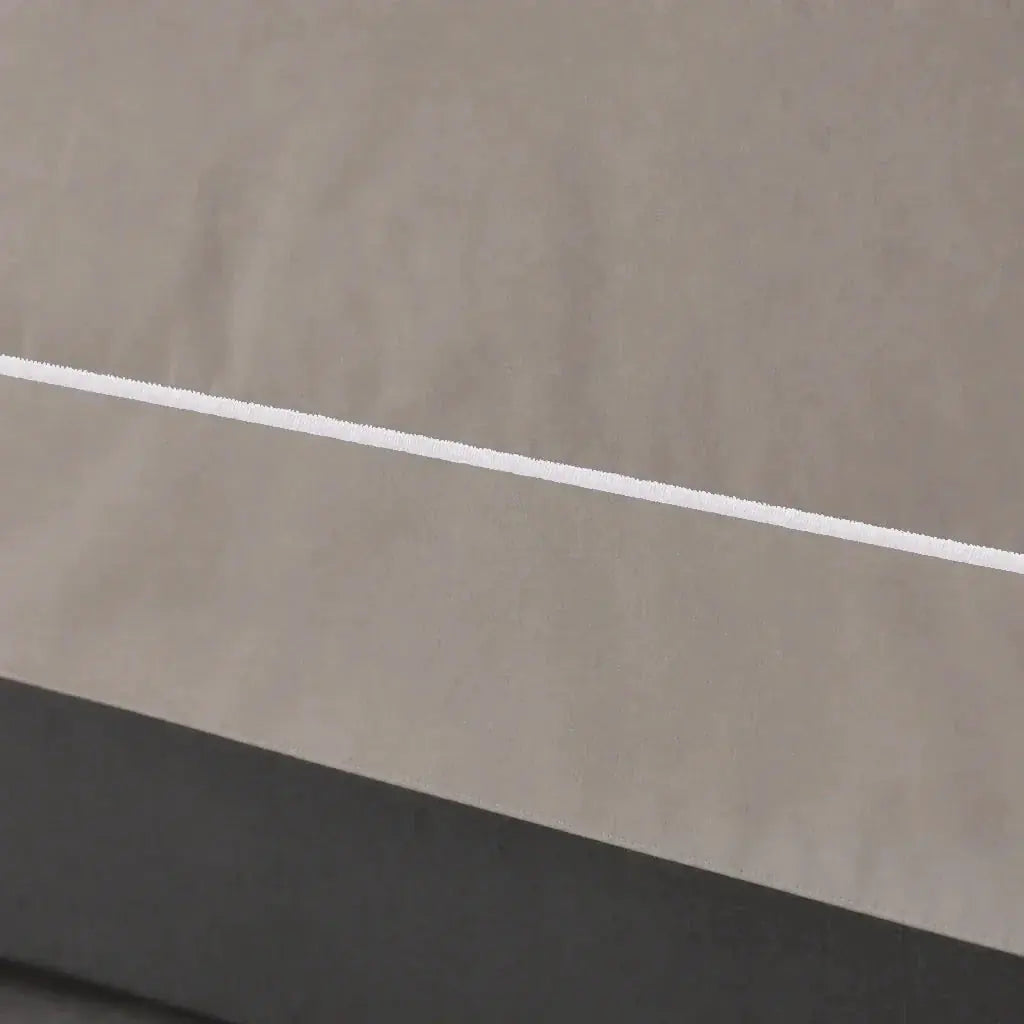 Close-up of the Stone Cotton 200TC Oxford duvet cover border with white one-row satin stitch.