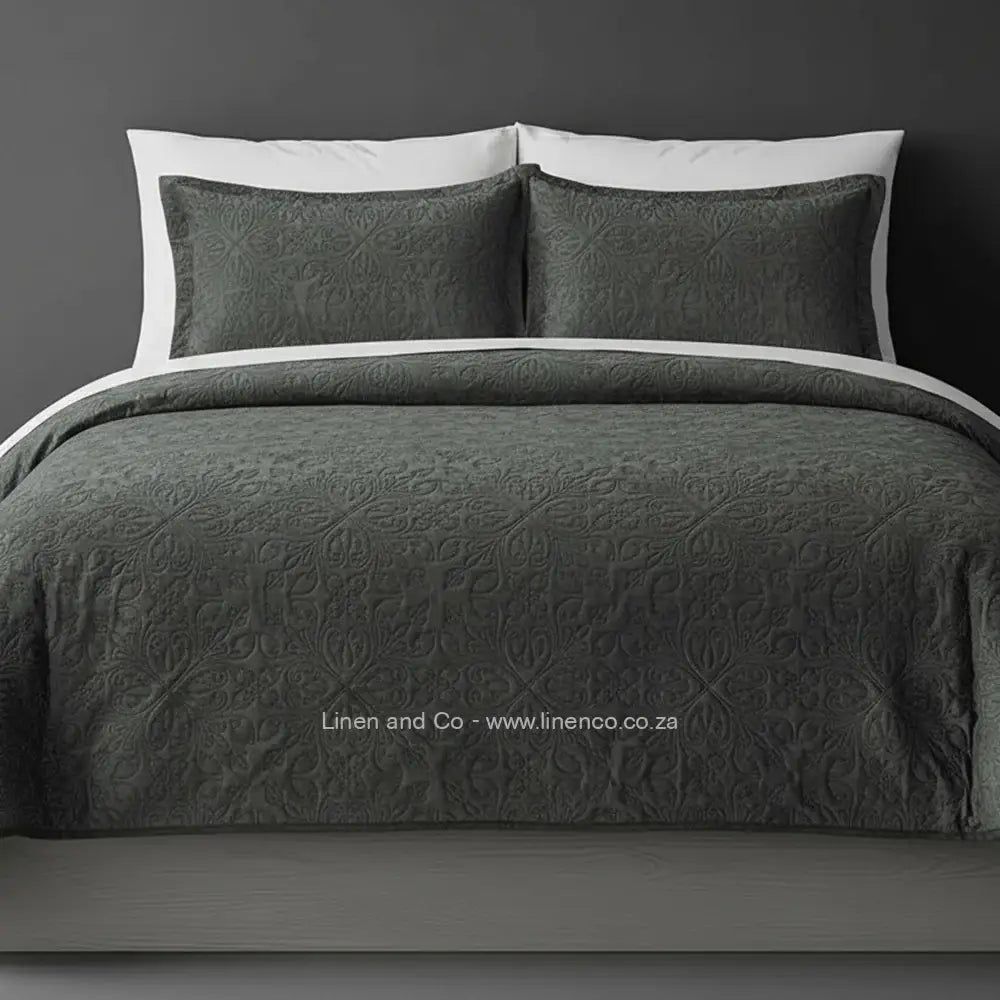 Dark Grey Quilted Bedspread Set with French Velvet, showcasing textured comforter and matching pillow cases on a bed against a dark grey wall, highlighting professional hospitality textile styling by Linen and Co.