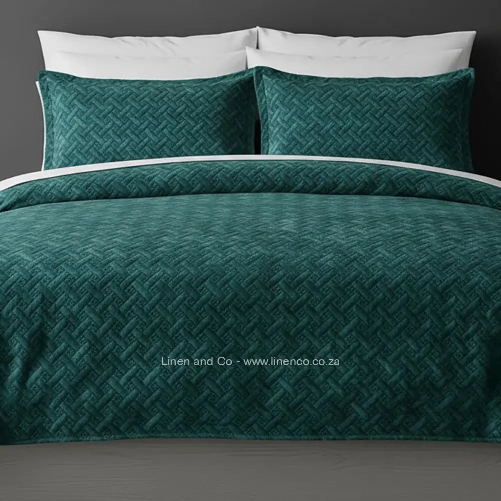 Teal Quilted Bedspread Set with Italian Velvet, showcasing textured comforter and matching pillow cases on a bed against a dark grey wall, highlighting professional hospitality textile styling by Linen and Co.