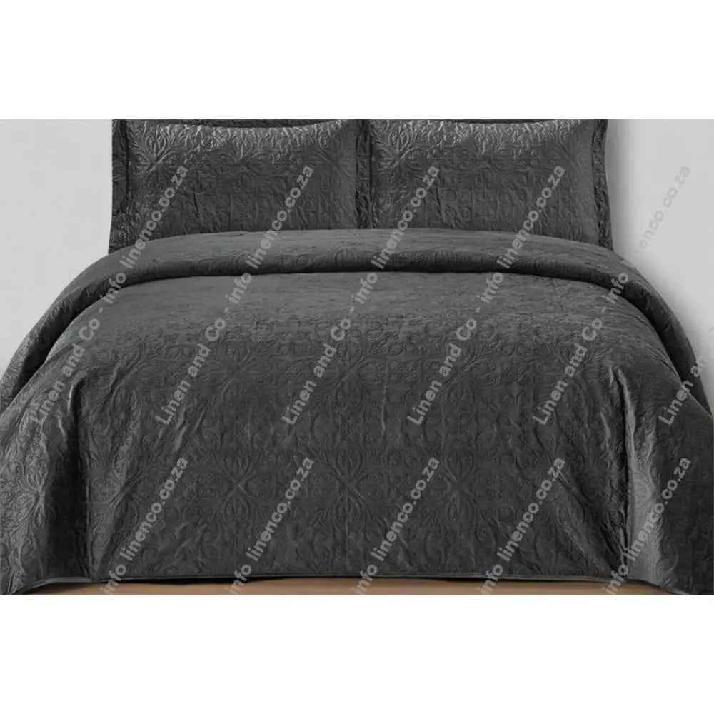Charcoal French velvet quilted bedding set on a bed with matching pillows