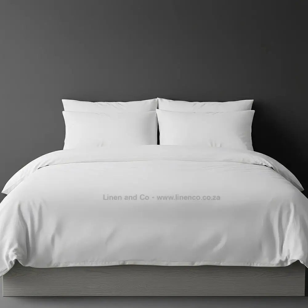 White percale duvet cover set from Linen and Co, showcasing pristine white bedding against a dark grey background, demonstrating clean and professional hospitality textile design