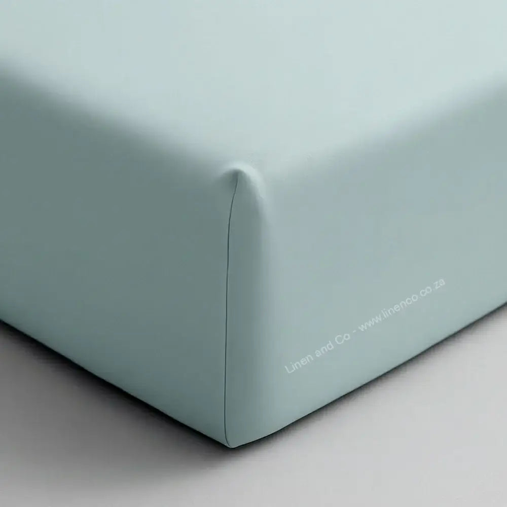 Duck Egg fitted sheet corner on mattress showing elastic edge and smooth percale fabric - Linen & Co hospitality bedding