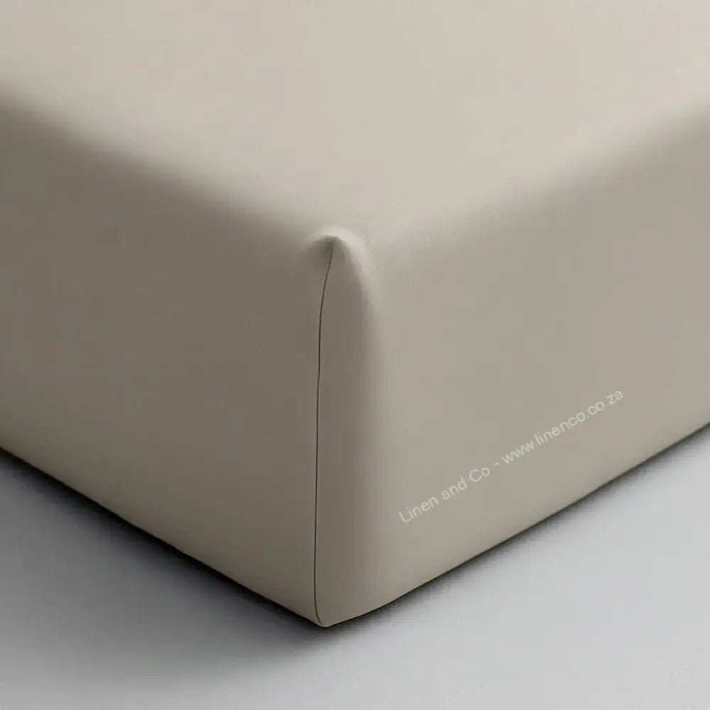 Stone fitted sheet corner on mattress showing elastic edge and smooth percale fabric - Linen & Co hospitality bedding