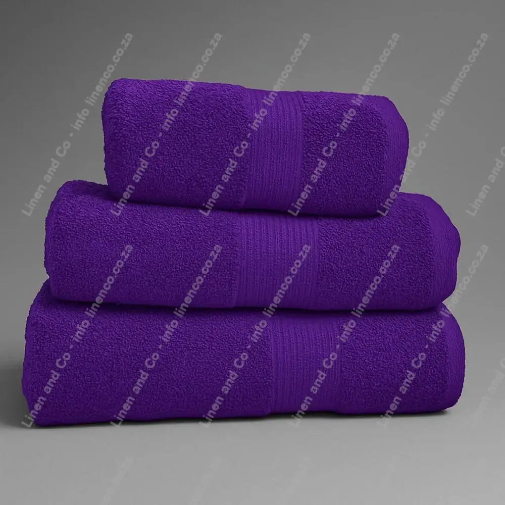 Linen and Co - Stack of three Aubergine  Purple Egyptian 450gsm towels stacked on a grey background.