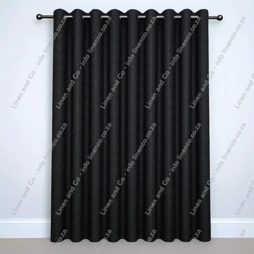 Charcoal Grey Eyelet curtain on a silver rod with silver ball finials.