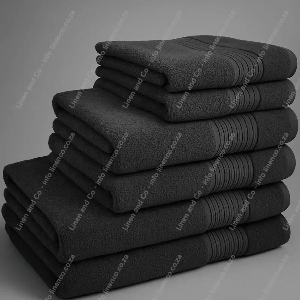 Linen and Co - Big and Soft Stack of dark grey towels on a grey background