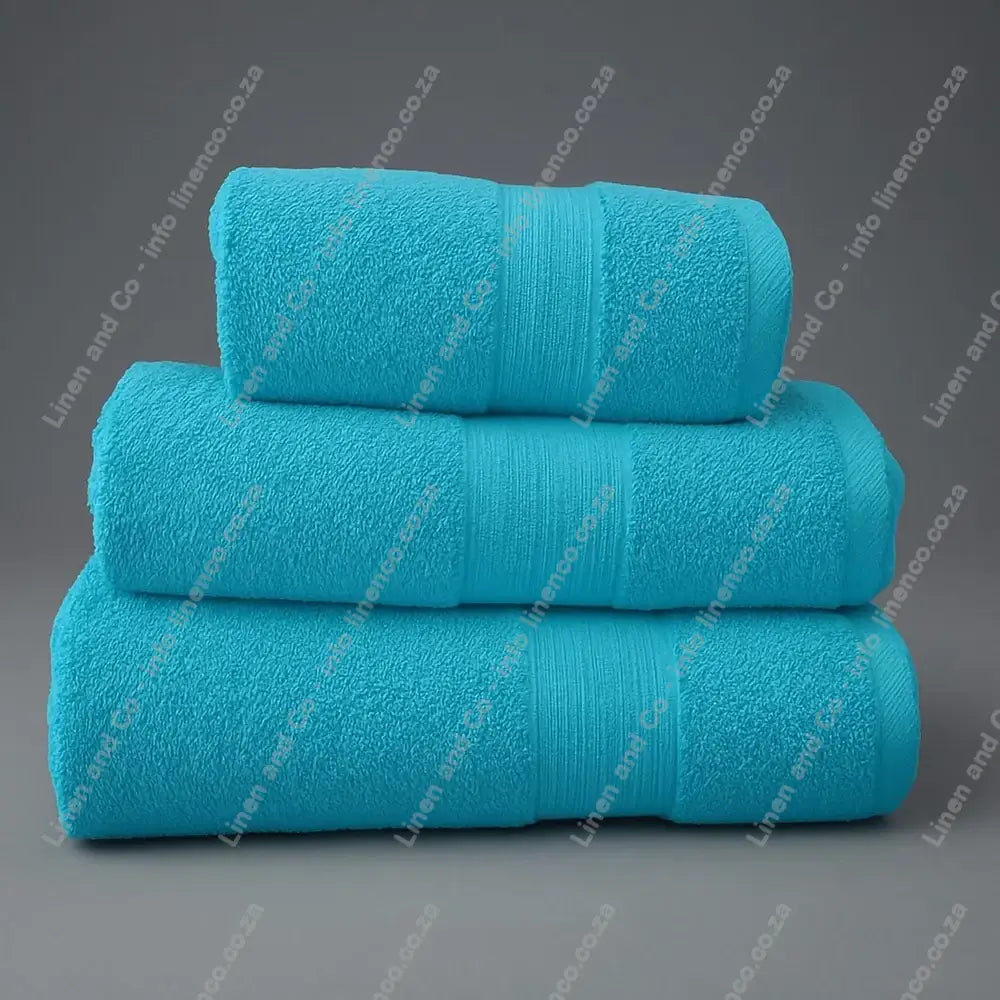 Linen and Co - Stack of three Duck Egg Egyptian 450gsm towels stacked on a grey background.