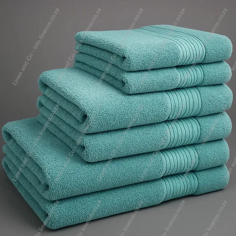 Linen and Co - Big and Soft Stack of duck egg towels on a grey background