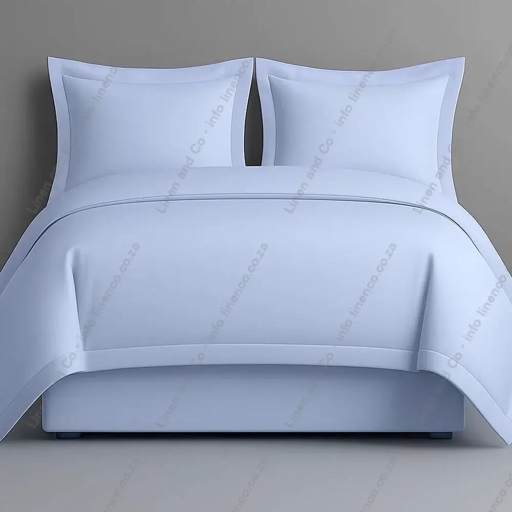 duck egg oxford bedding set with two pillows on a grey background