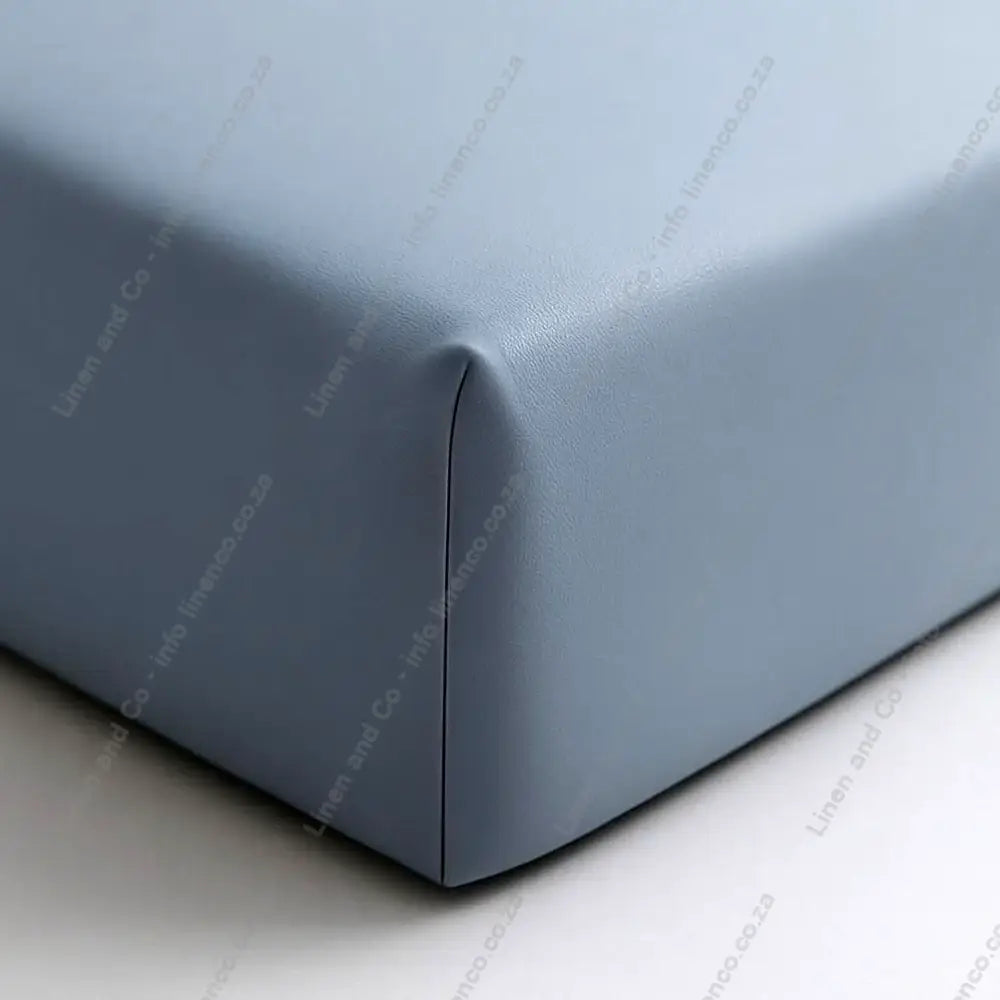 Duck Egg Close-up of a fitted sheet on a bed corner with a plain background