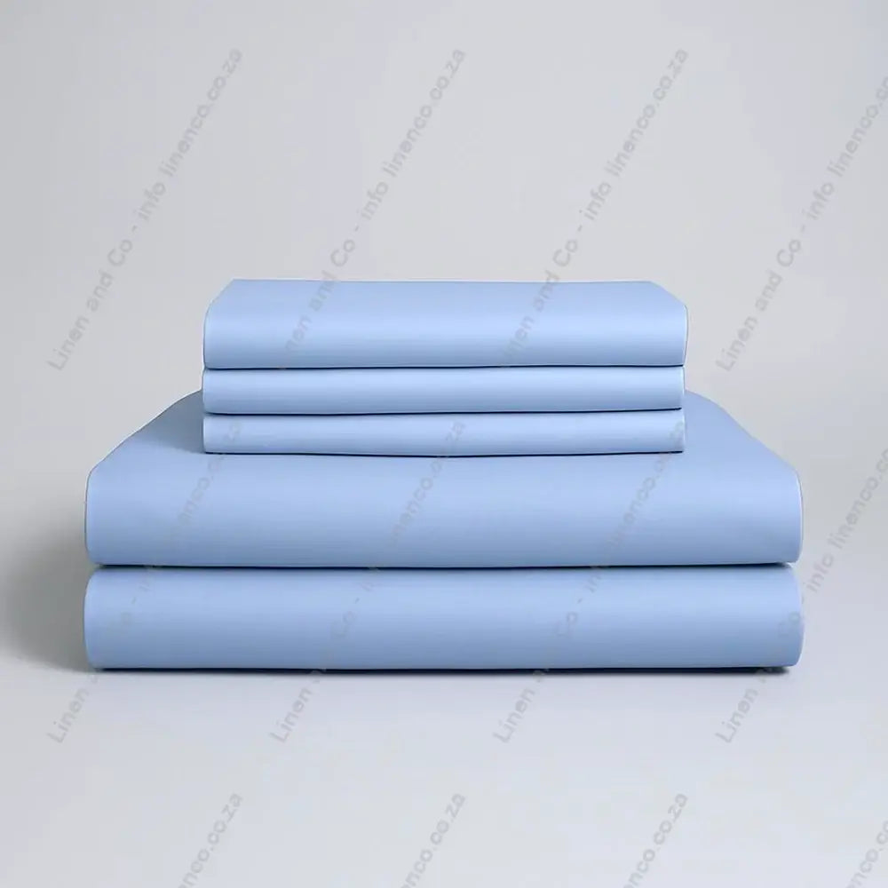 Set of duck Egg folded bed sheets on a grey background