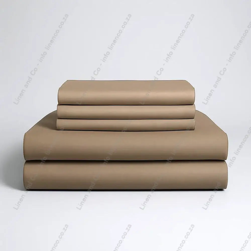Set of stone folded bed sheets on a grey background