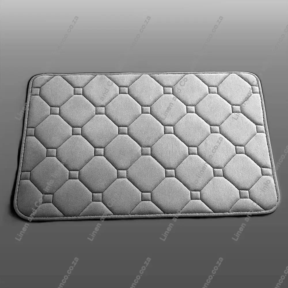 Grey Memory Foam textured bath mat on a light grey background