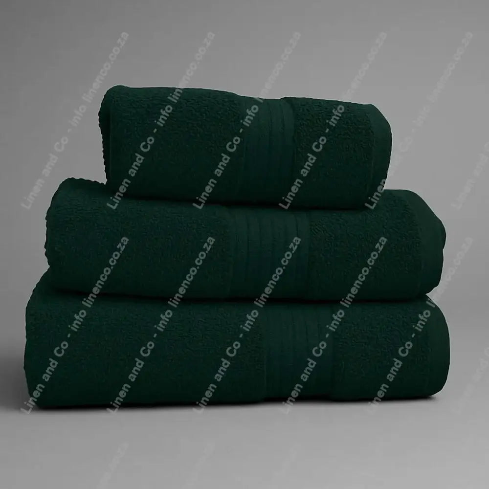 Linen and Co - Stack of three Hunter Green Egyptian 450gsm towels stacked on a grey background.