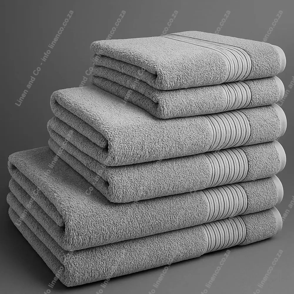 Linen and Co - Big and Soft Stack of light grey towels on a grey background