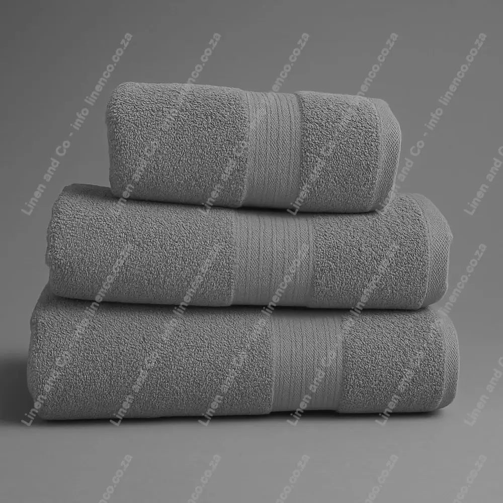 Linen and Co - Stack of three Light Grey Egyptian 450gsm towels stacked on a grey background.