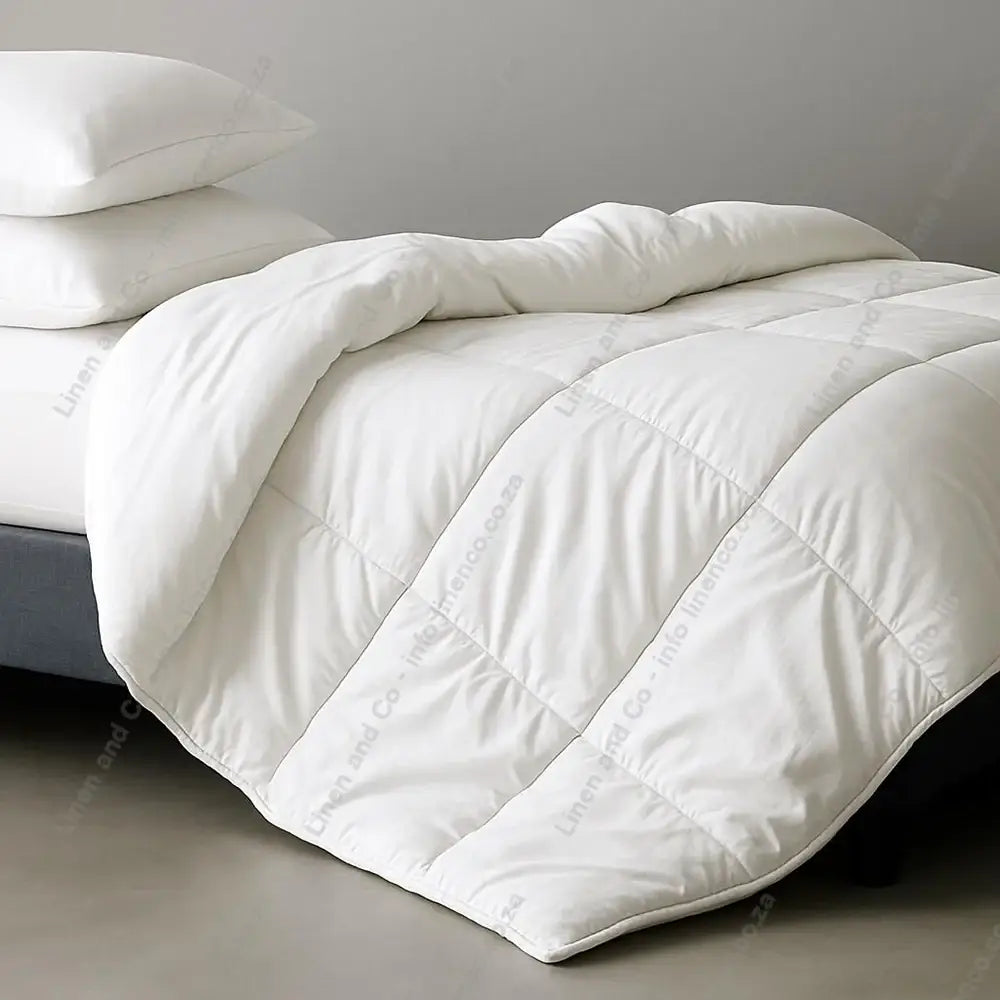 White Luxury Microfiber Duvet Inner and pillows on a bed with a neutral background