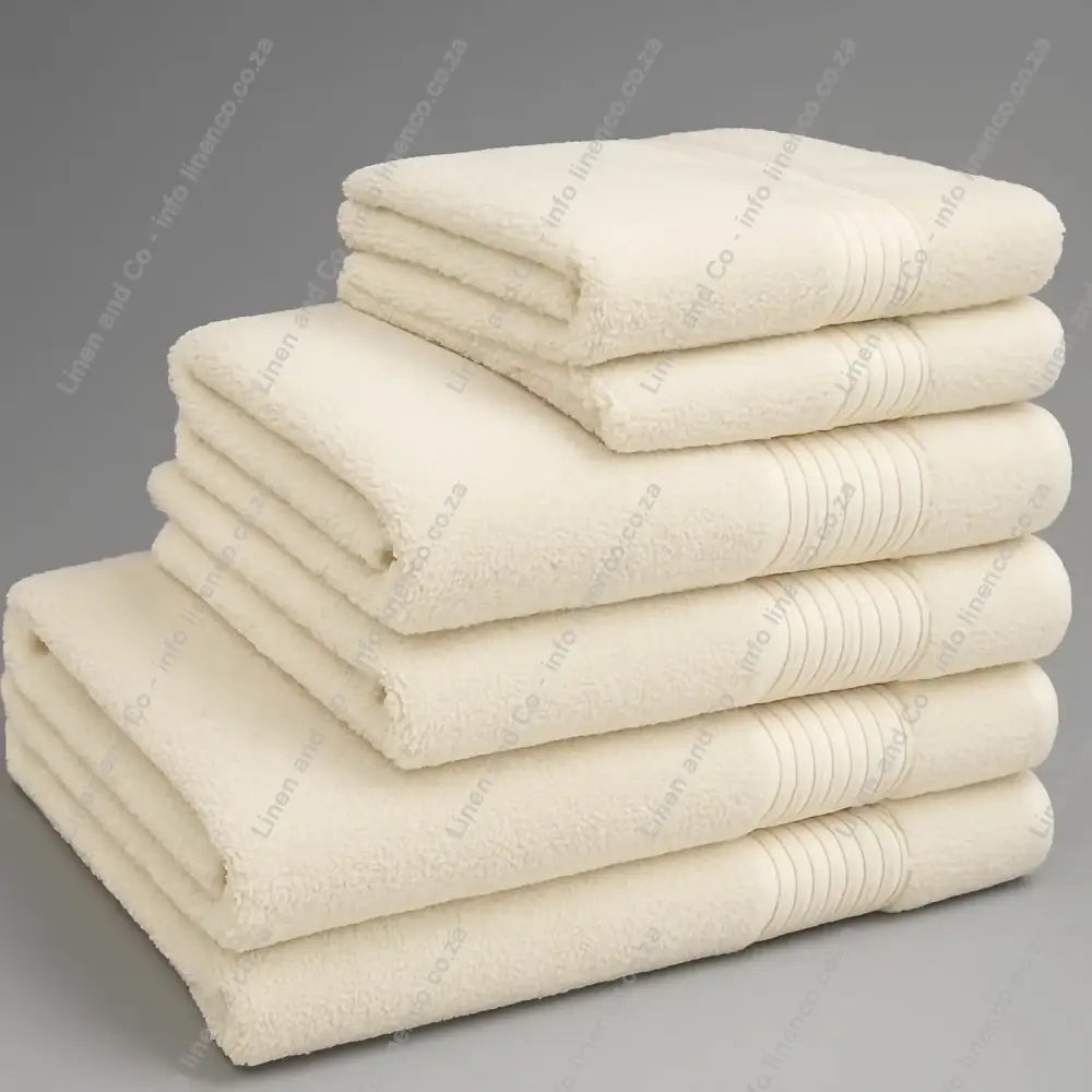 Linen and Co - Big and Soft Stack of macadamia (light cream) towels on a grey background