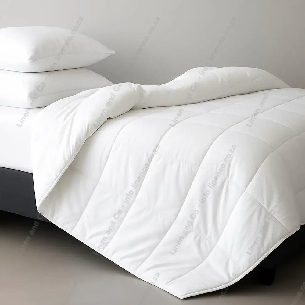 White Natural Cotton Summer Duvet Inner and pillows on a bed with a neutral background