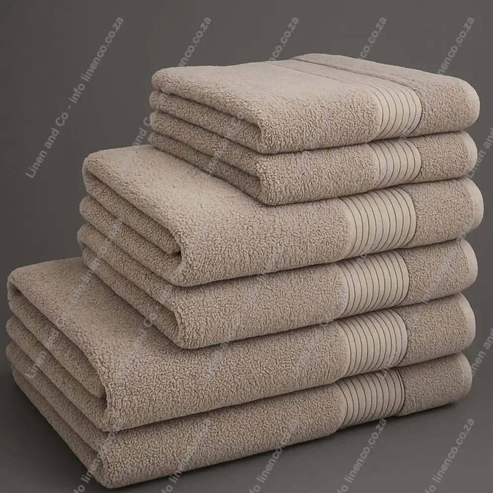 Linen and Co - Big and Soft Stack of pebble towels on a grey background