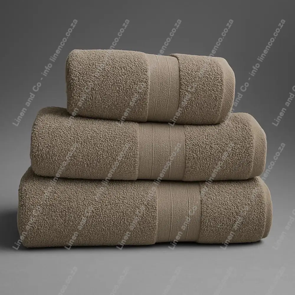 Linen and Co - Stack of three Pebble Egyptian 450gsm towels stacked on a grey background.