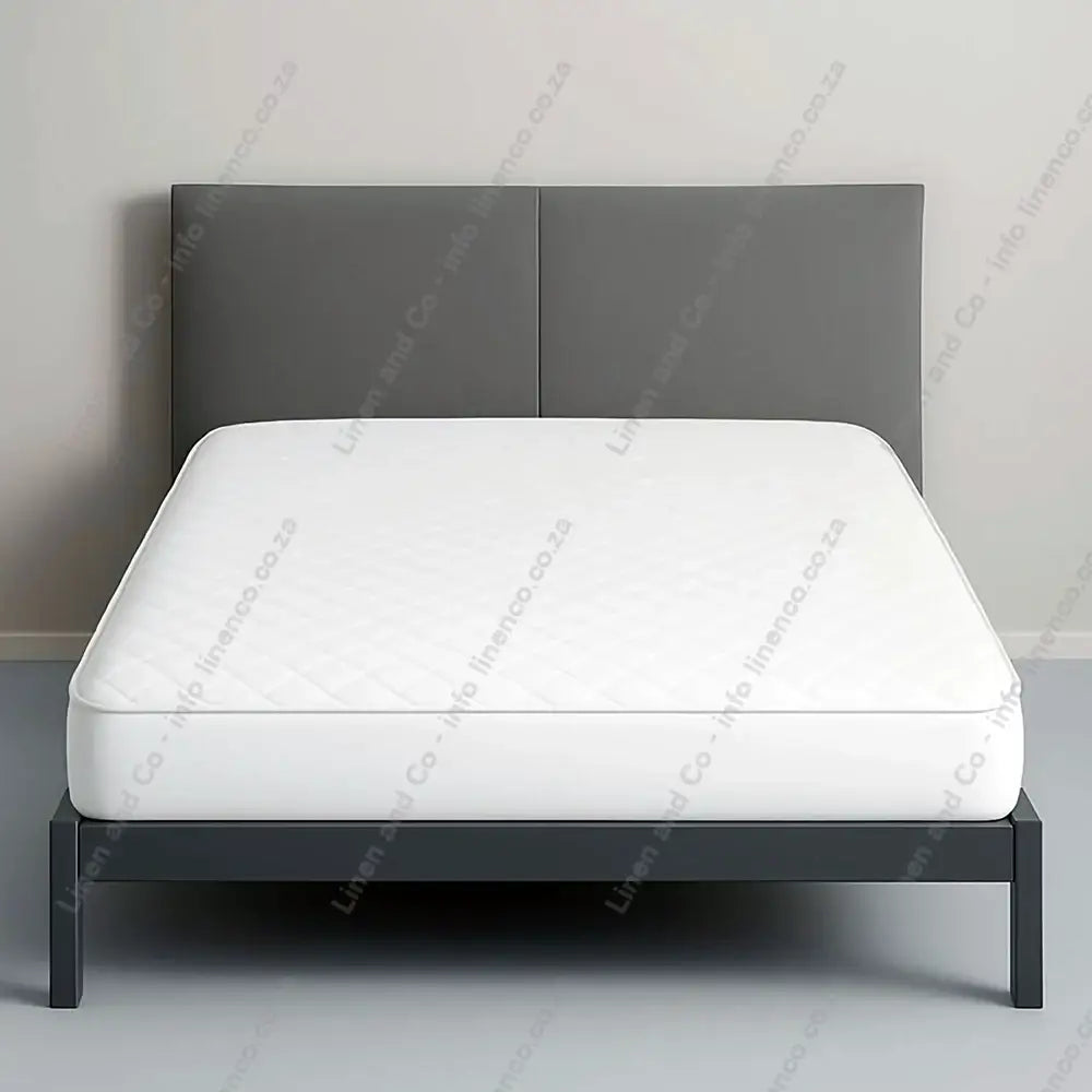 Quilted Wetsafe Mattress Protector on a bed with a grey background