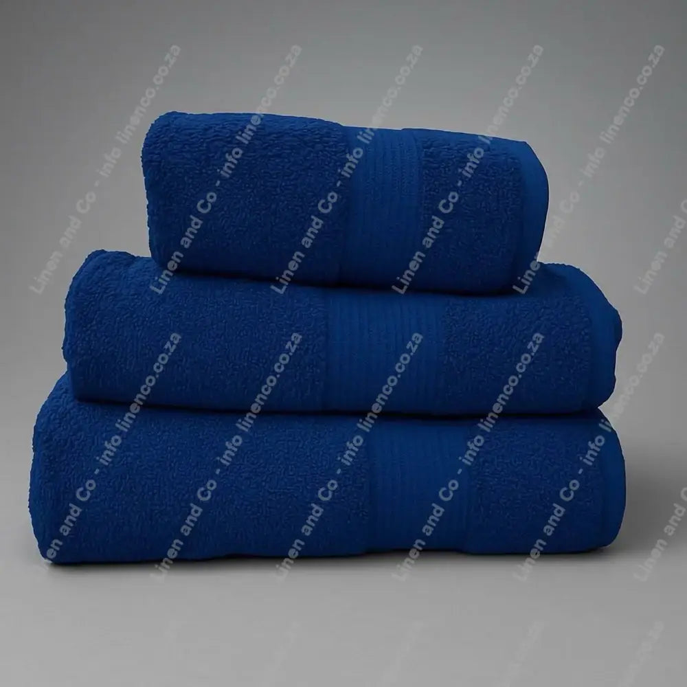 Linen and Co - Stack of three Royal Blue Egyptian 450gsm towels stacked on a grey background.