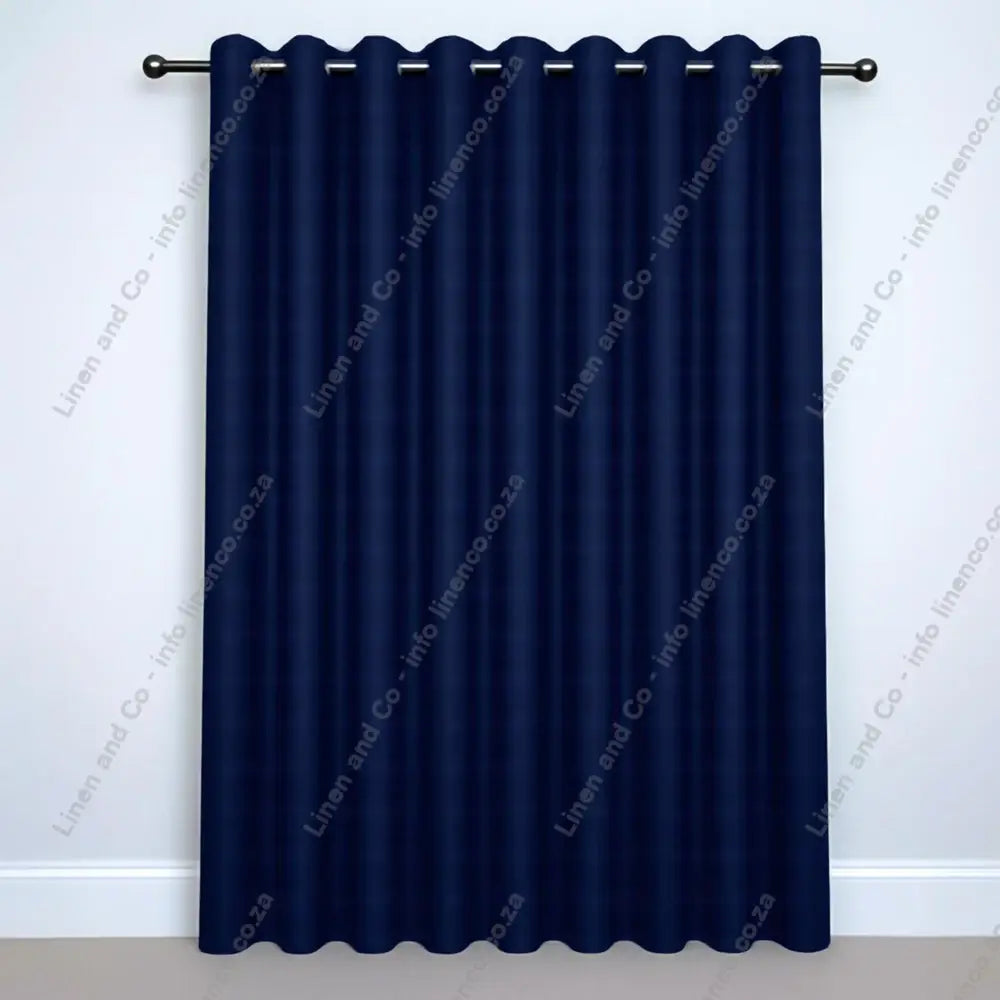 Navy Blue Eyelet Woven Blockout curtain on a silver curtain rod