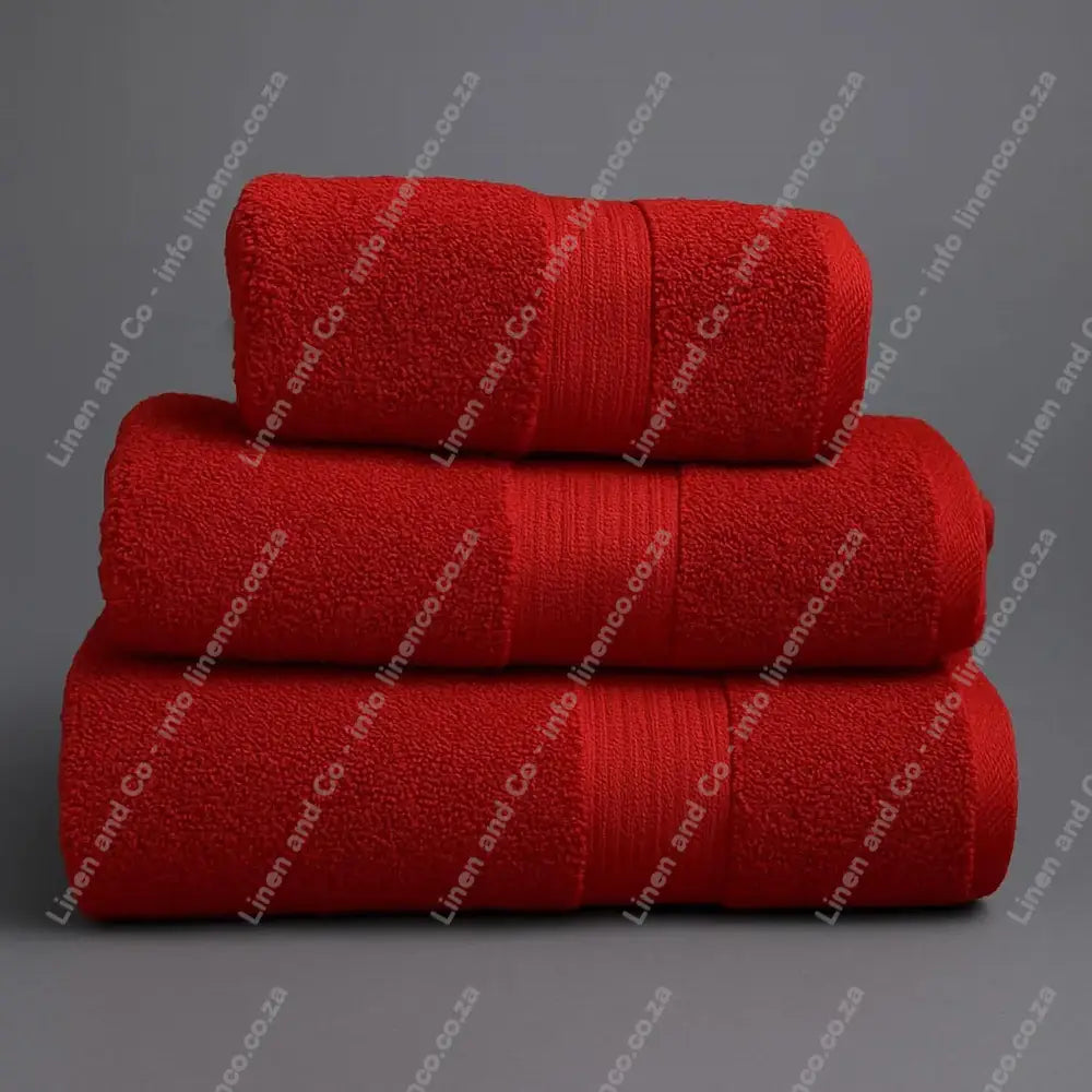 Linen and Co - Stack of three Rust Egyptian 450gsm towels stacked on a grey background.
