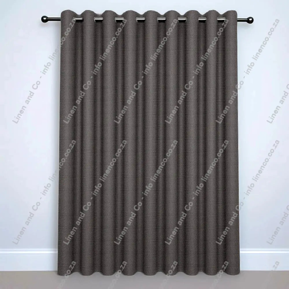 Stone Grey Eyelet curtain on a silver rod with silver ball finials.