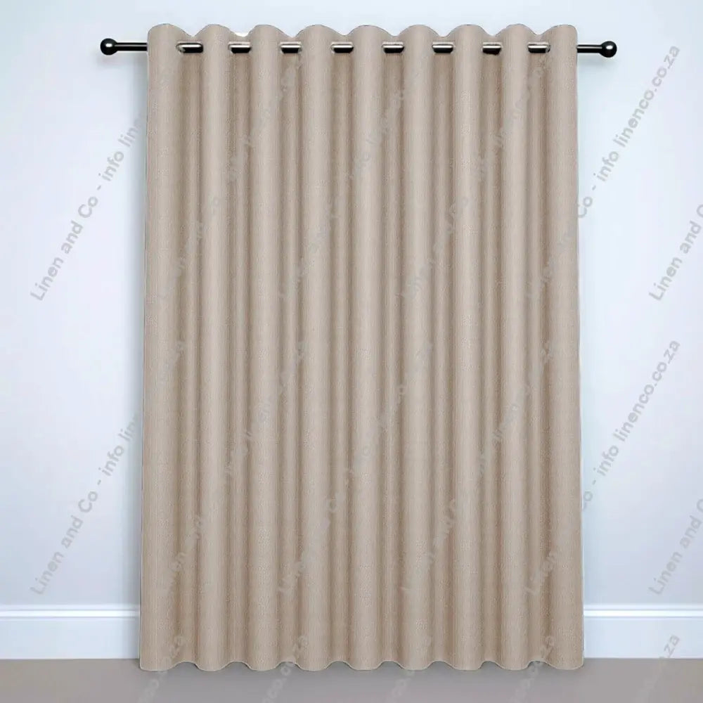 Taupe Eyelet curtain on a silver rod with silver ball finials.