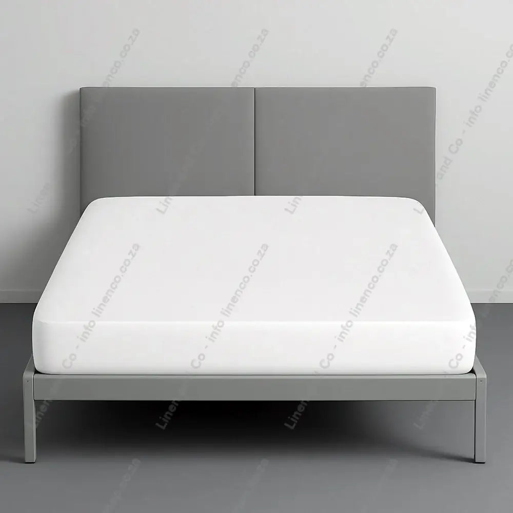 Towelling Wetsafe Mattress Protector on a bed with a grey background