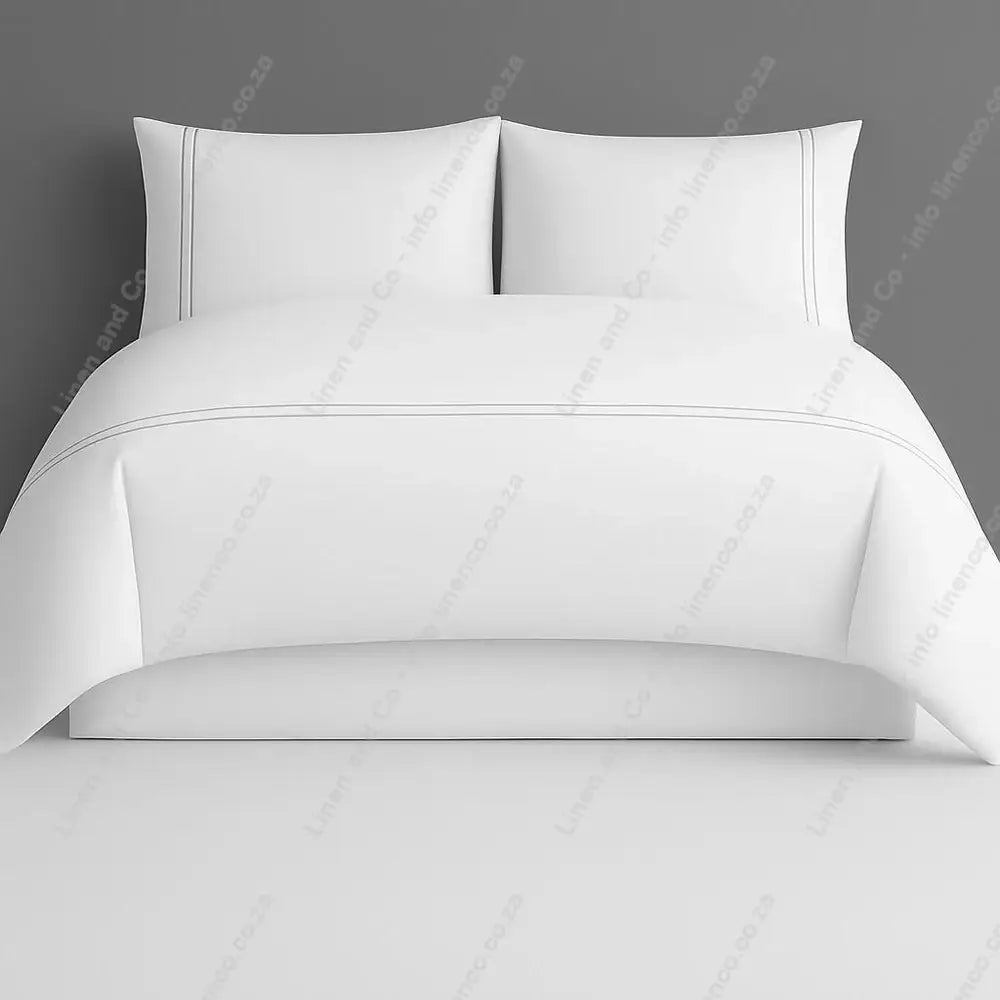 White two row side satin stitch duvet cover set with a grey background.
