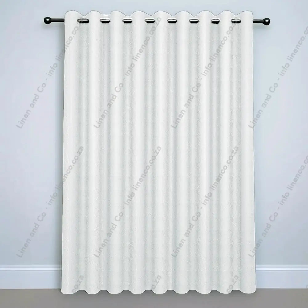White Eyelet Woven Blockout curtain on a silver curtain rod