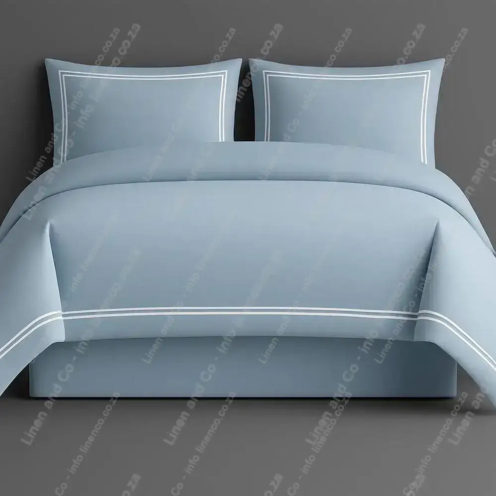 Duck Egg Oxford Duvet Cover with white two row satin stitch with matching pillow cases on a grey background