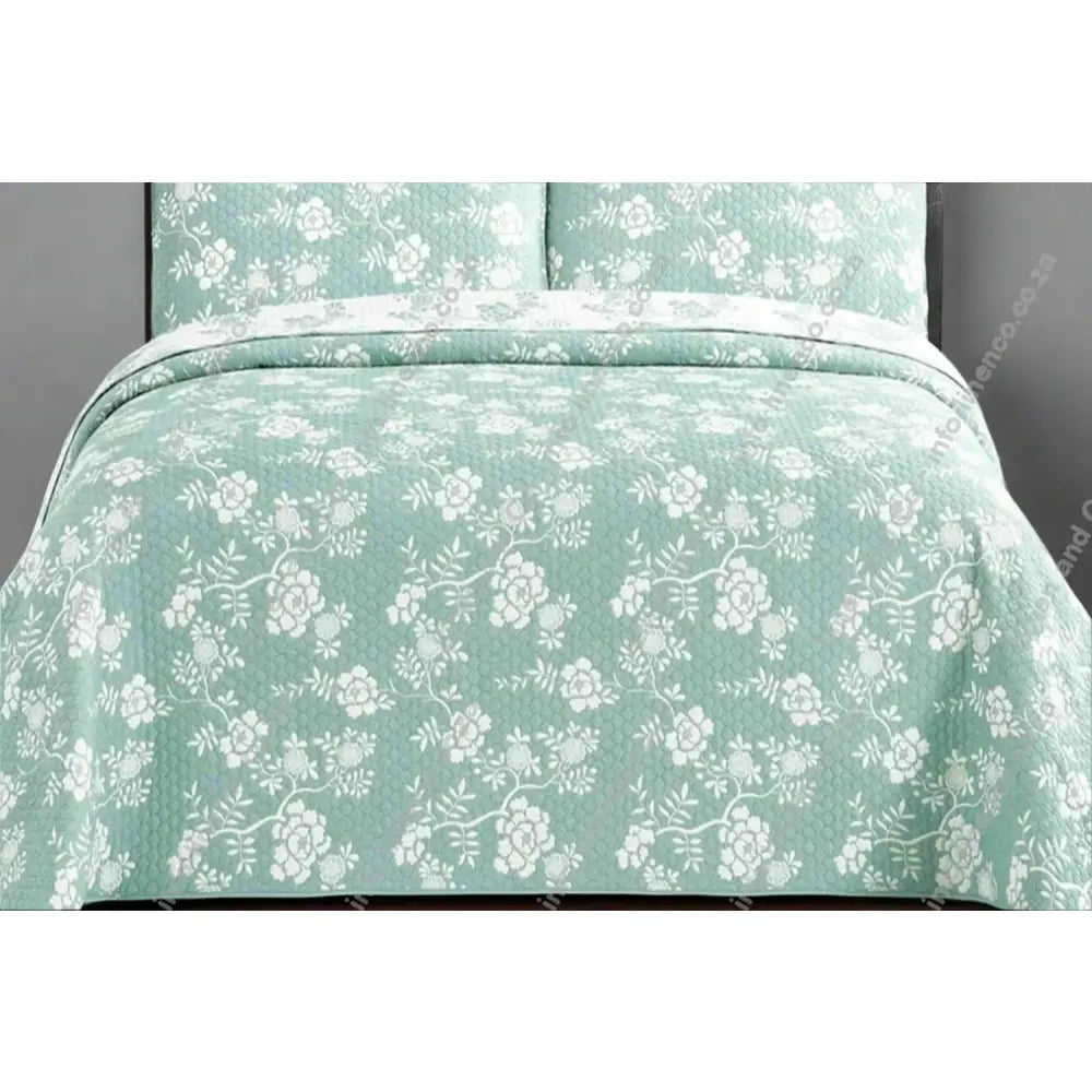 Rochelle Design Floral patterned Marine quilt on a bed with matching pillows.